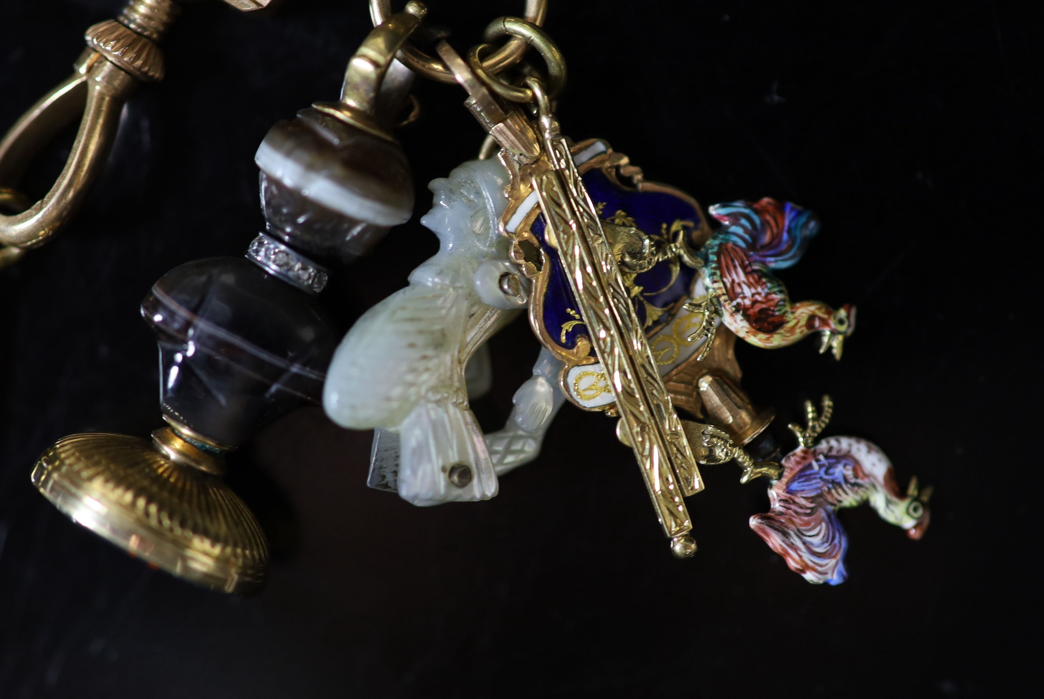 An early 19th century French or Swiss gold and enamel chatelaine, hung with eleven assorted accoutrements